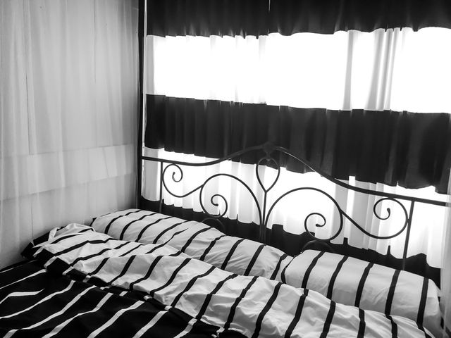 habitacion con cortinas negras y blancas con cama